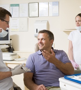 A dentist talking to his male patient