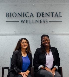 Woman in dental office smiling at dentist