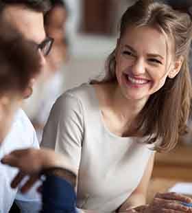 Young female professional smiling with colleagues