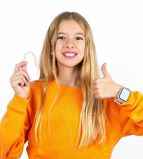 Teenage girl holding Invisalign Teen aligner