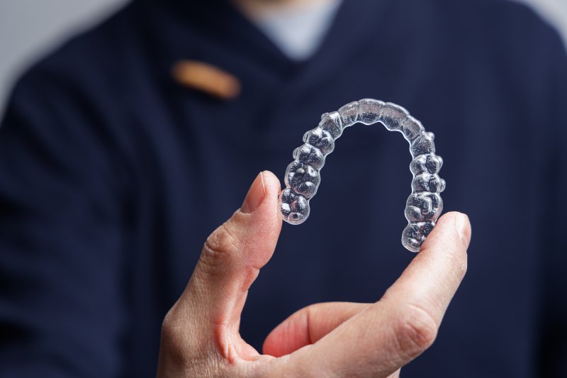 person holding Invisalign aligner